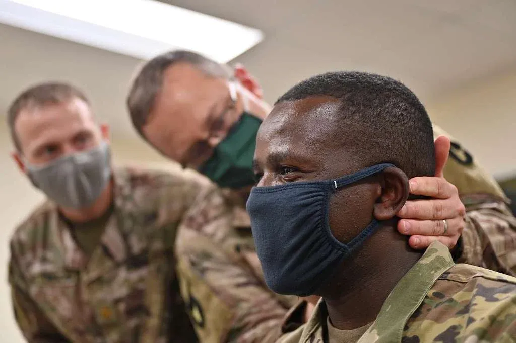 man holding soldiers neck after receiving bfa treatment, smiling