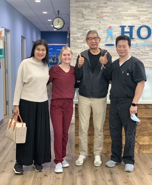 Patient with family and HOPE Clinic staff giving thumbs up in lobby
