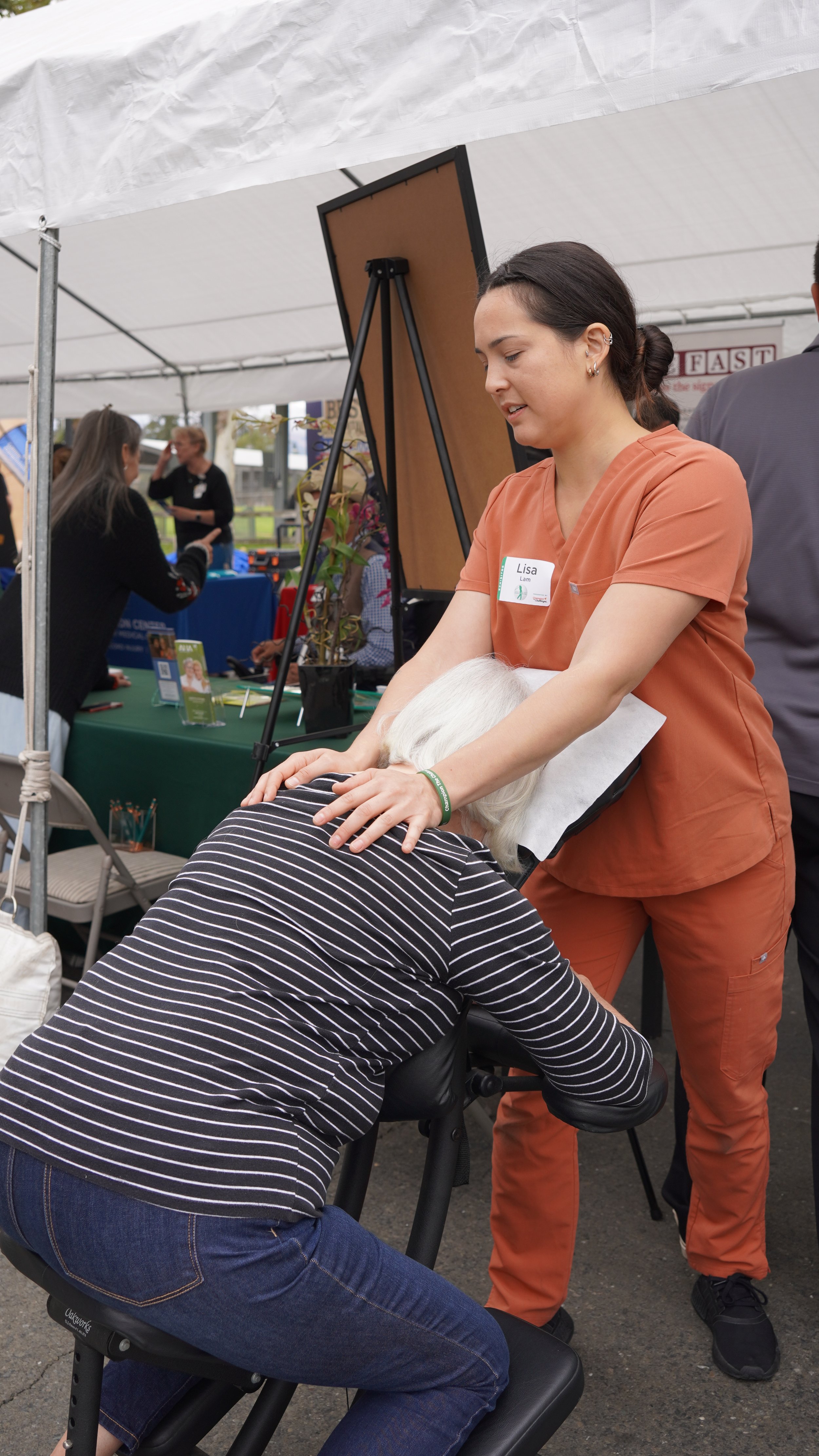 HOPE massage therapist giving back massage to visitor at community health fair