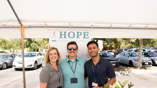 Three HOPE Clinic team members posing at outdoor community health fair