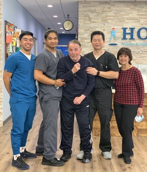 Patient with walker celebrating recovery with HOPE Clinic staff, all hands raised