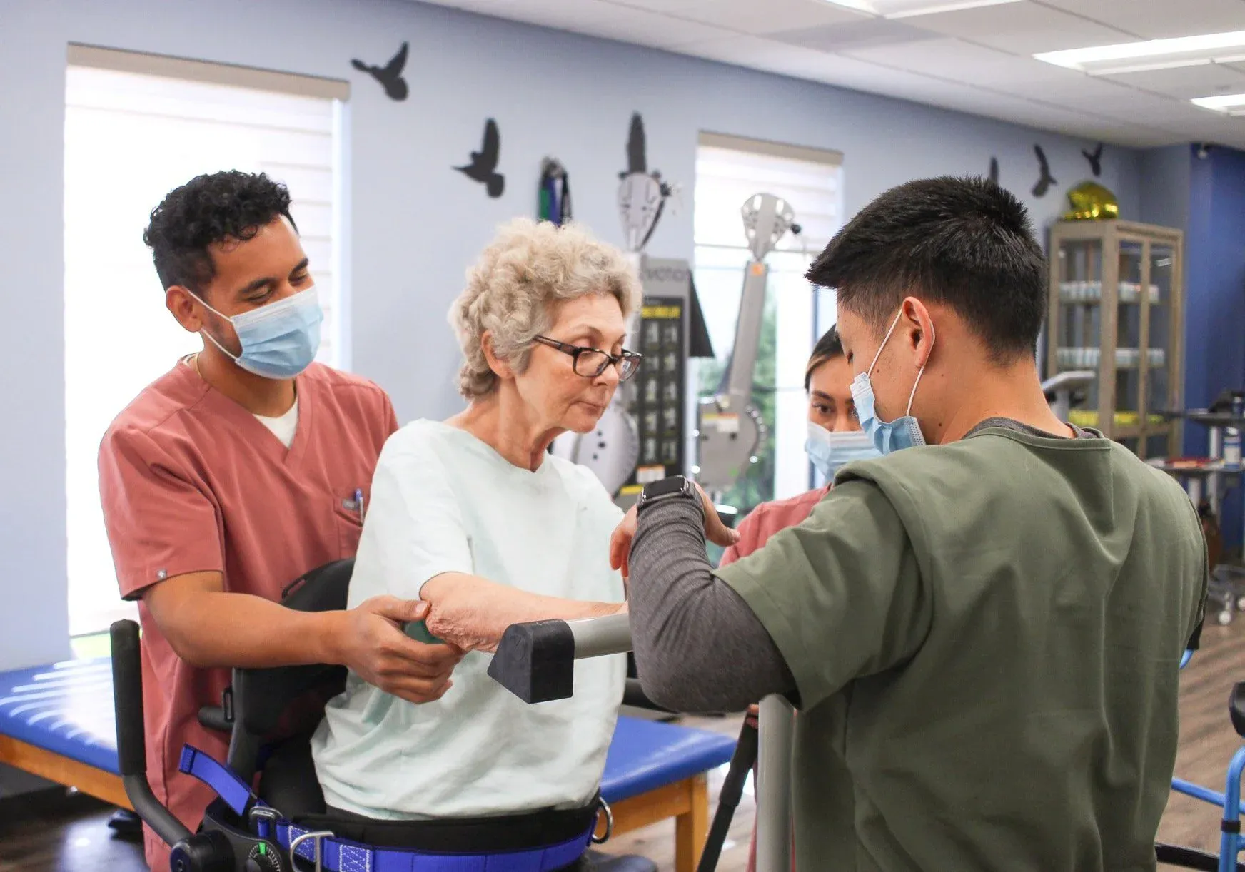 Healthcare professionals assisting a patient with rehabilitation exercises